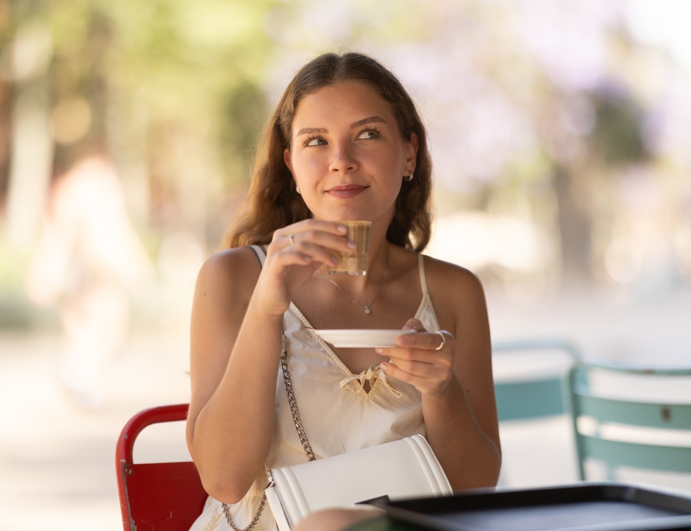 Devojka uživa u šoljici kafe u prijatnom ambijentu kafića