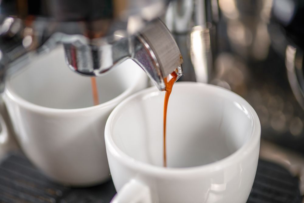 Espresso koji se sipa iz aparata u šolje u kafiću